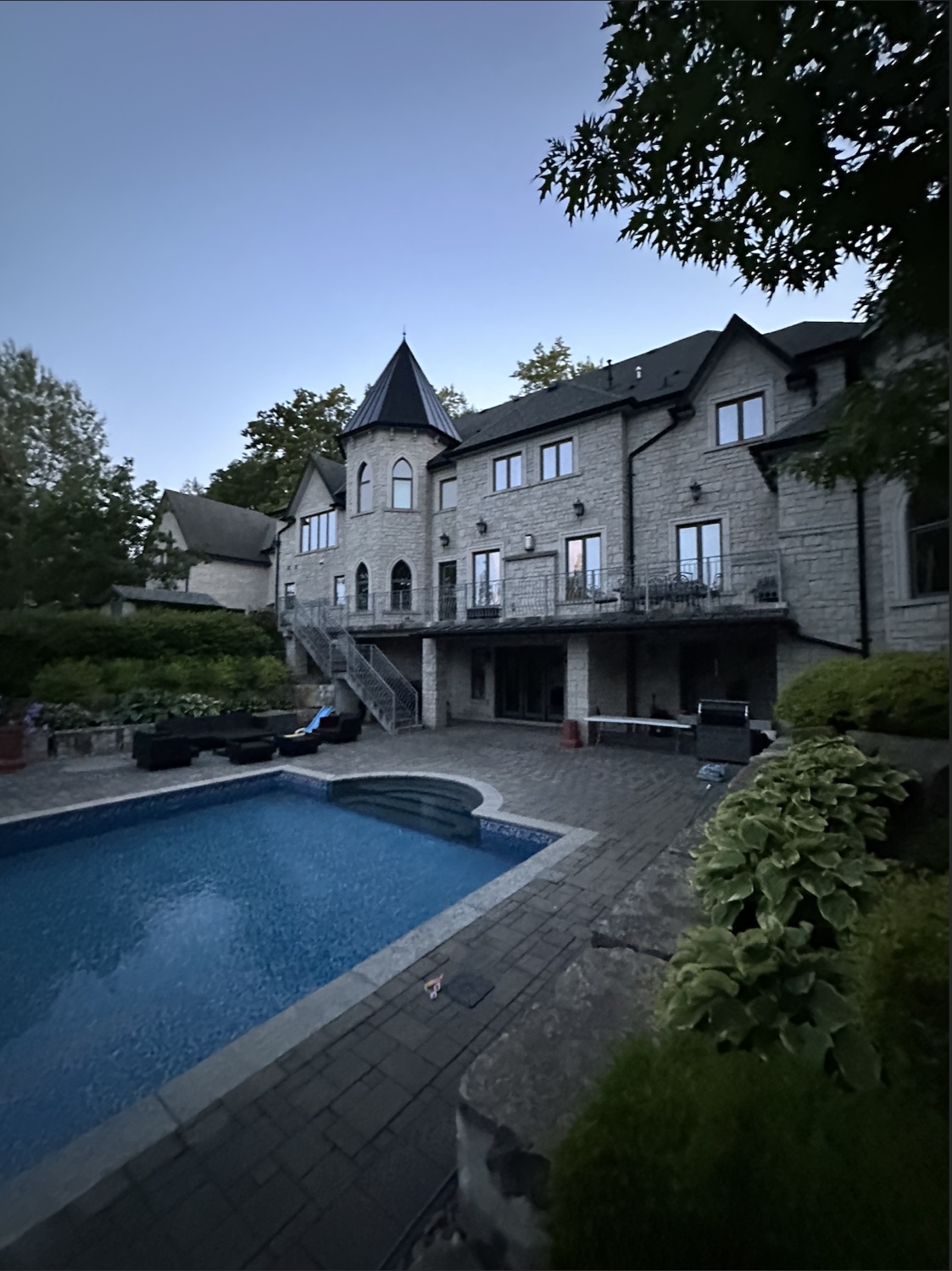 Stone home with turret overlooking a pool