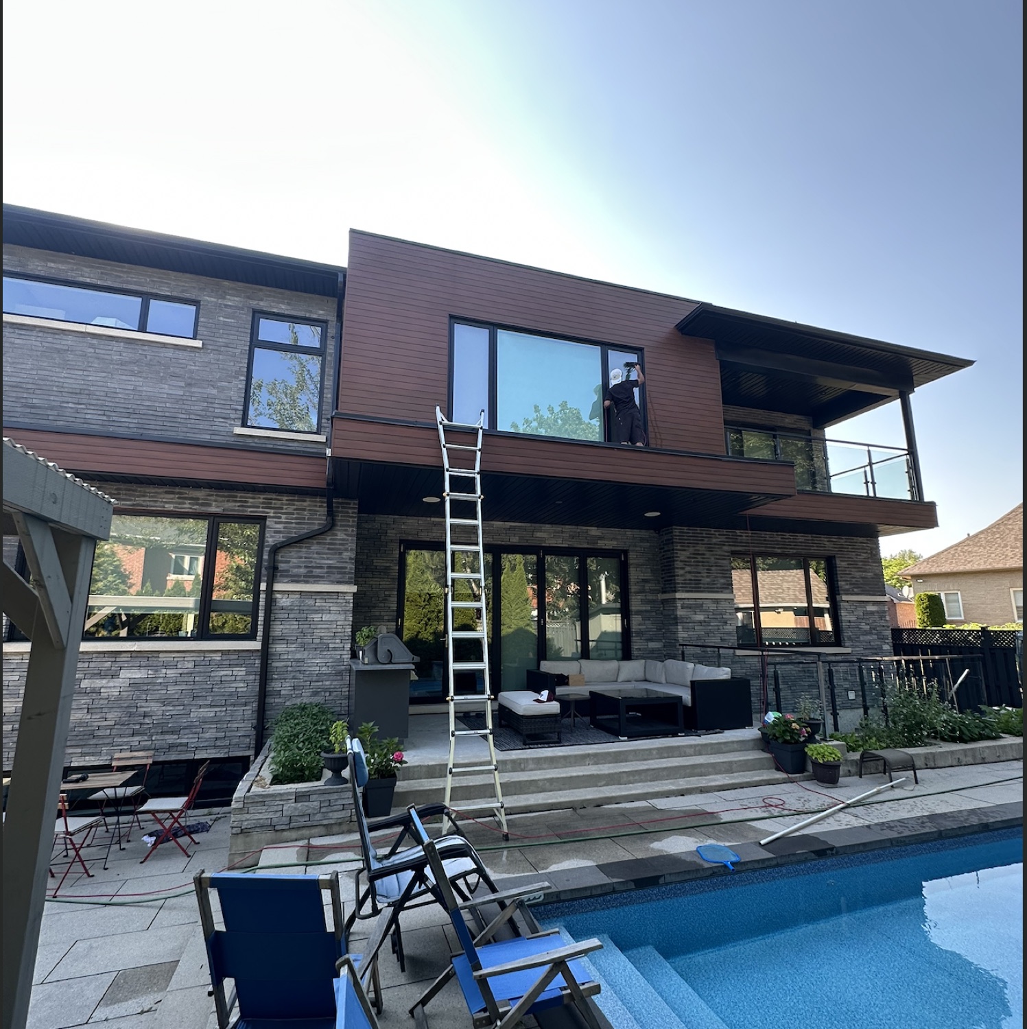 Cleaning balcony windows above a pool
