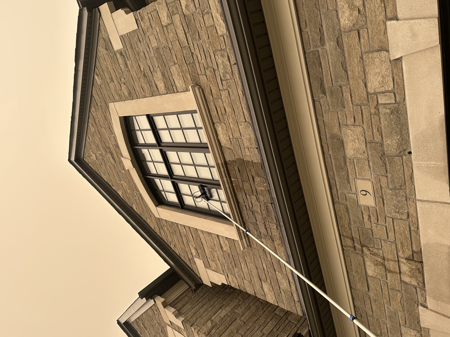 Water-fed pole cleaning an arched window