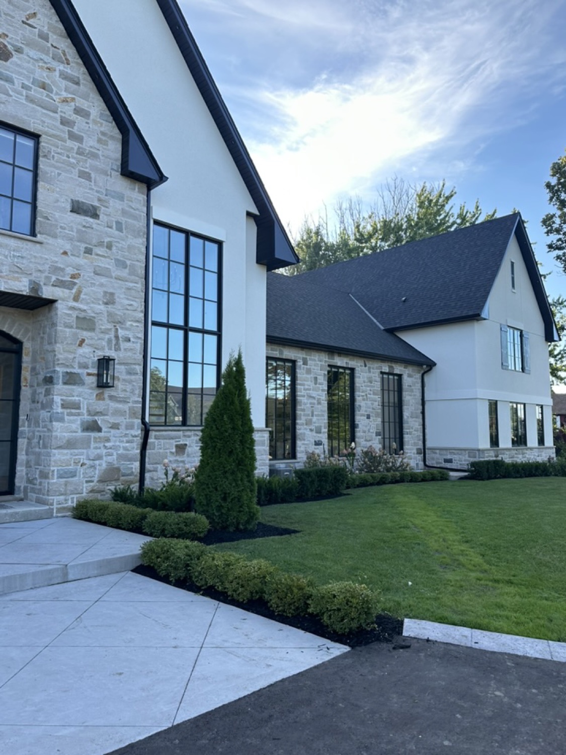Stone and stucco home with manicured gardens